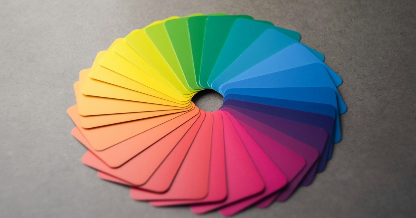 Colour swatch cards fanned out in a full circle from yellow through green, blue, purple, pink and orange