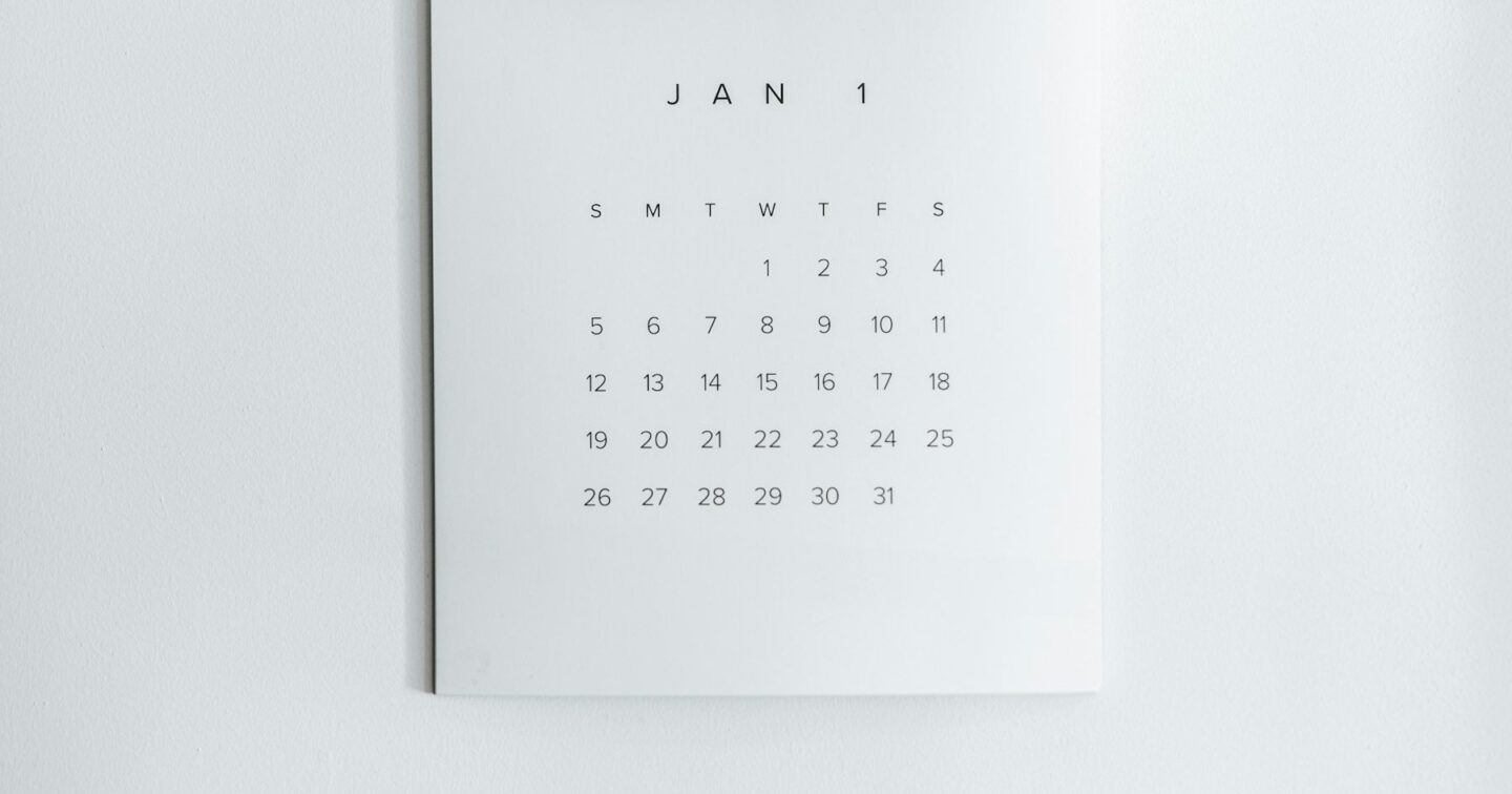 Minimal monthly wall calendar hanging on a plain white wall