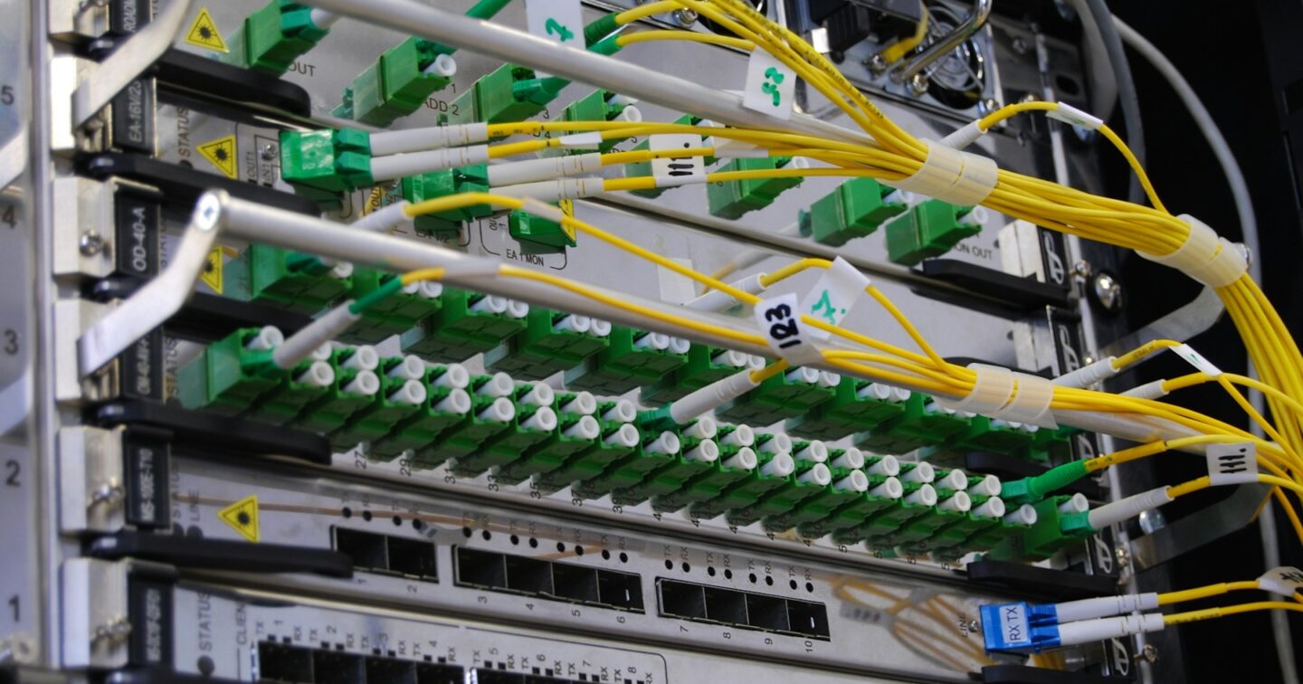 Fibre optic cables connected to a network switch in a server rack