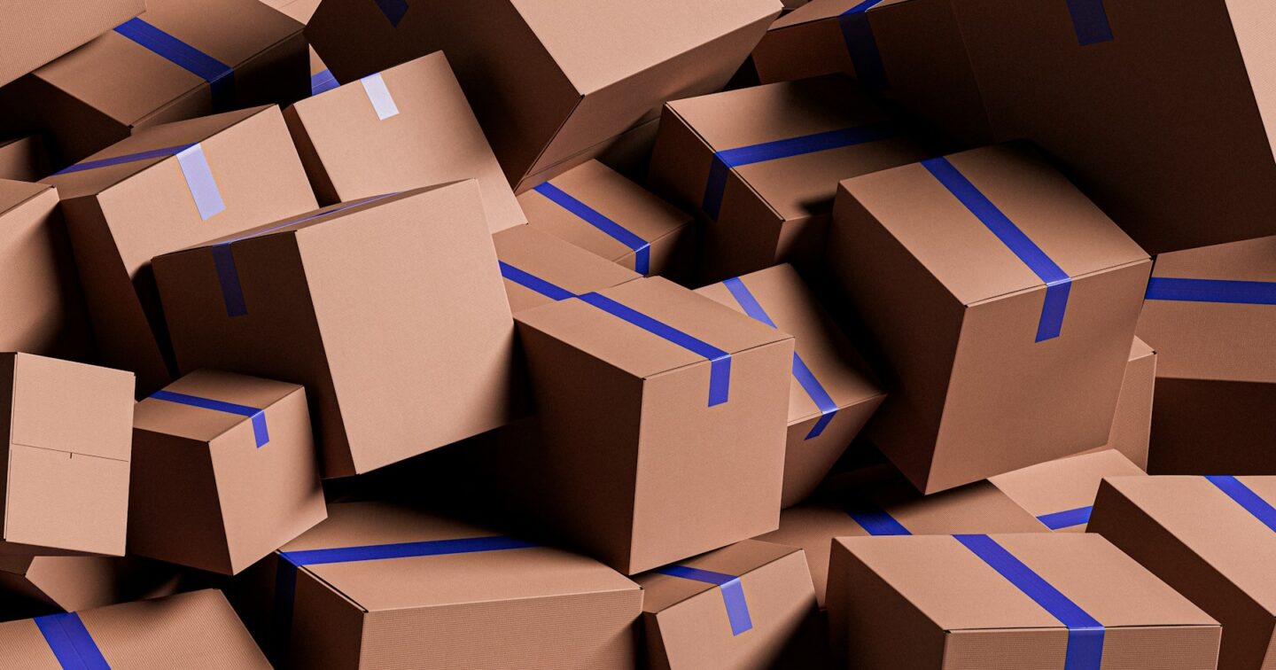 A pile of brown cardboard parcels sealed with blue tape, ready for dispatch